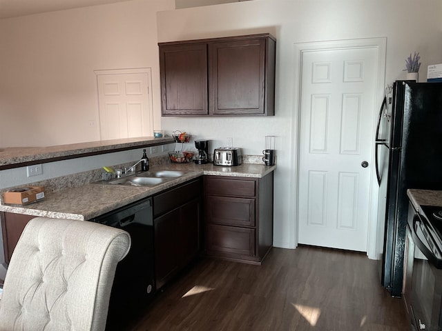 kitchen with a peninsula, dark brown cabinets, dark wood-style floors, a sink, and black appliances