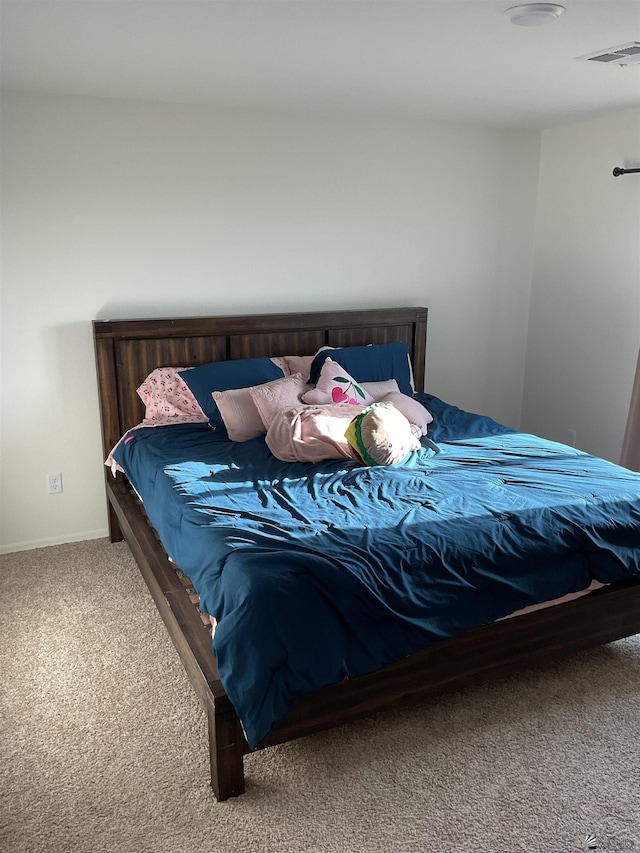 carpeted bedroom with visible vents and baseboards