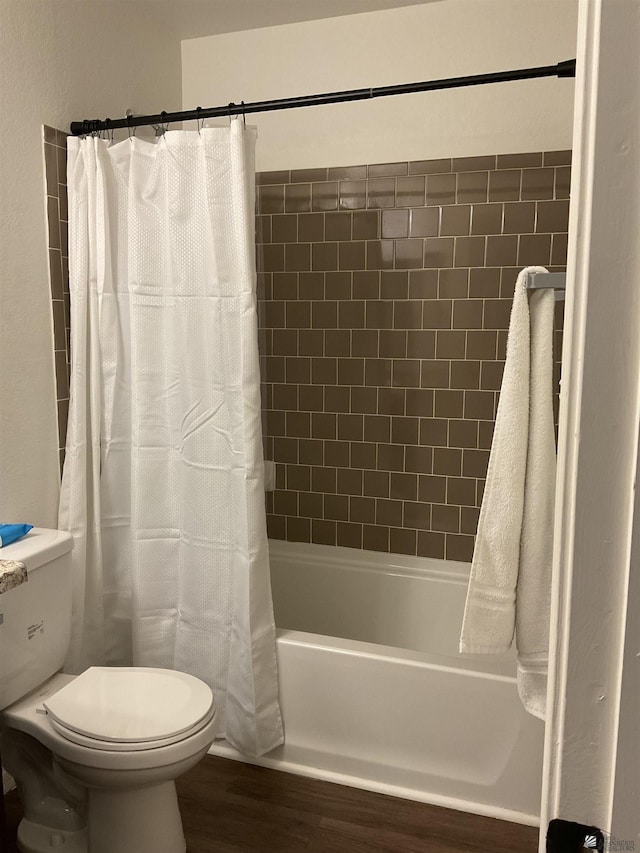 bathroom with toilet, wood finished floors, and shower / bath combo with shower curtain