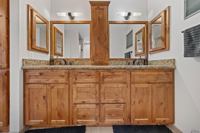 1215 S 41st Dr, Yuma, AZ 85364 - bathroom featuring a textured wall, double vanity, and baseboards