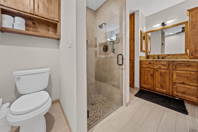 1215 S 41st Dr, Yuma, AZ 85364 - bathroom with toilet, a stall shower, vanity, and baseboards