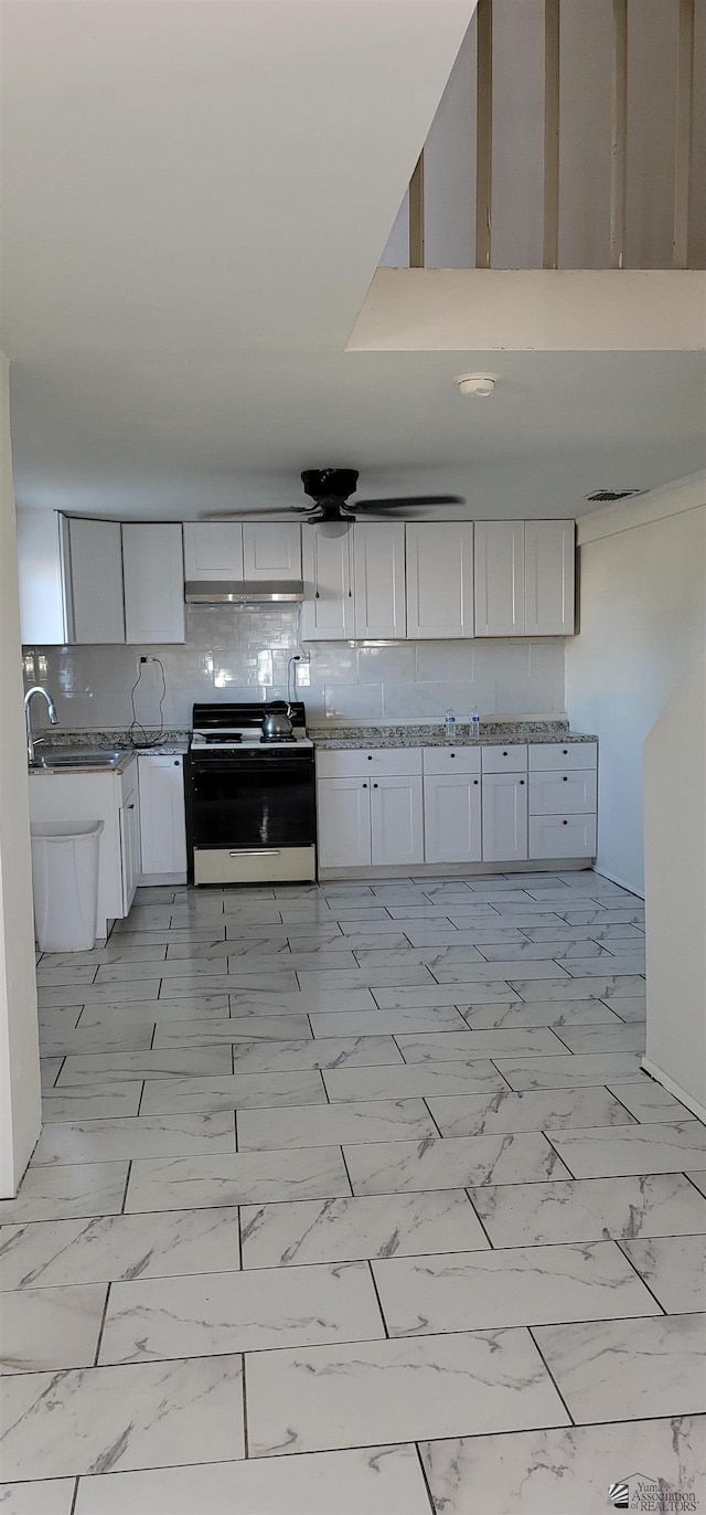 kitchen featuring white cabinets, marble finish floor, and range