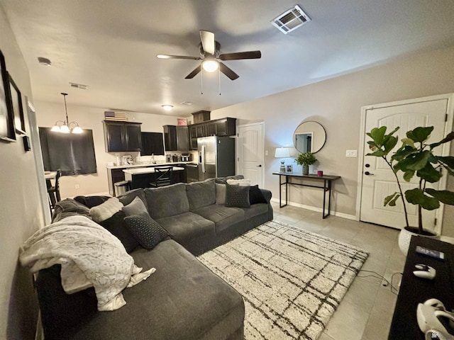 living room featuring baseboards, ceiling fan, visible vents, and light tile patterned floors