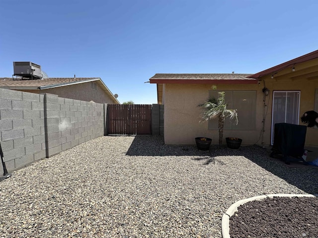 11228 E 25th St, Yuma, AZ 85367 - view of side of home with central air condition unit, a gate, and stucco siding