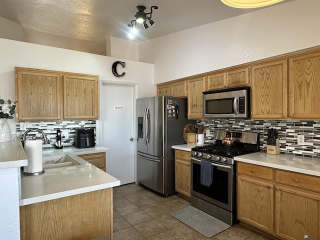 11228 E 25th St, Yuma, AZ 85367 - kitchen featuring stainless steel appliances, decorative backsplash, light countertops, a sink, and brown cabinetry