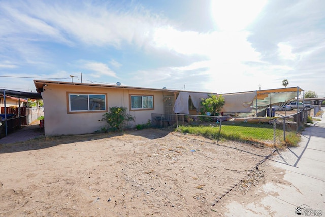 view of front of house featuring stucco siding and fence