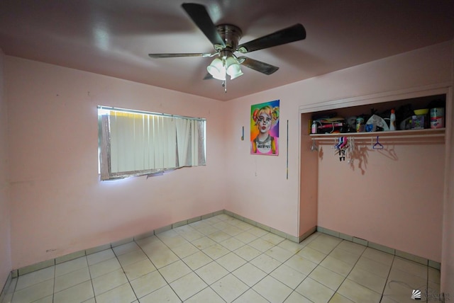 unfurnished bedroom with baseboards, ceiling fan, a closet, and light tile patterned flooring