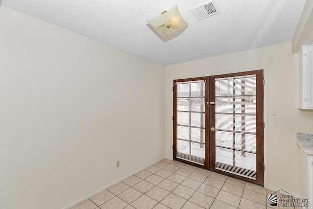 2413 W 13th Pl, Yuma, AZ 85364 - unfurnished dining area with a textured ceiling, light tile patterned floors, and baseboards