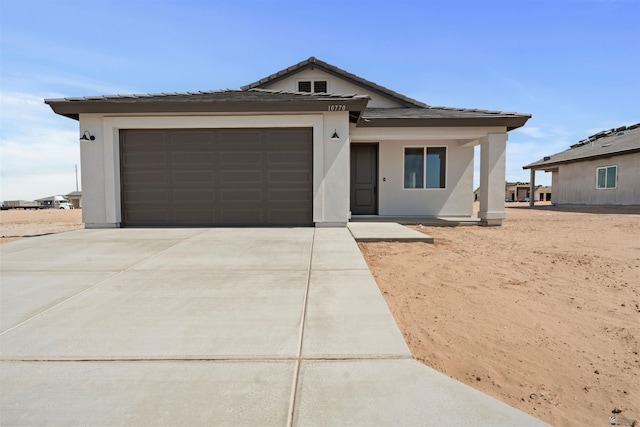 10778 E 45th Ln, Yuma, AZ 85367 - view of front facade featuring concrete driveway, an attached garage, a tile roof, and stucco siding