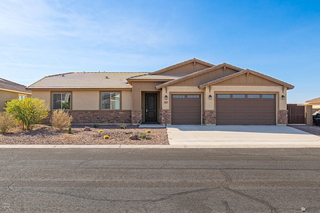 view of front facade featuring a garage, stone siding, and concrete driveway