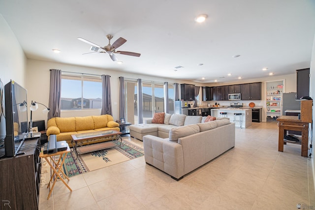 living area featuring light tile patterned floors, a ceiling fan, and recessed lighting