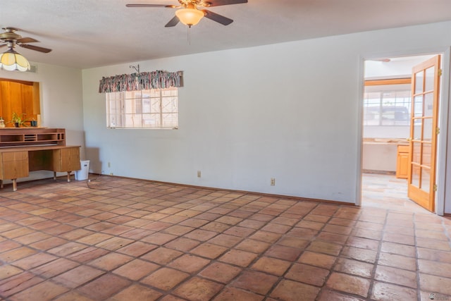 unfurnished living room featuring baseboards, a ceiling fan, and a healthy amount of sunlight
