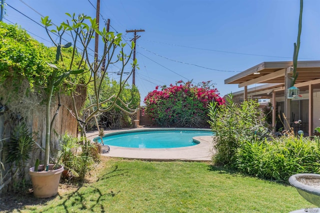 outdoor pool with a lawn and a fenced backyard