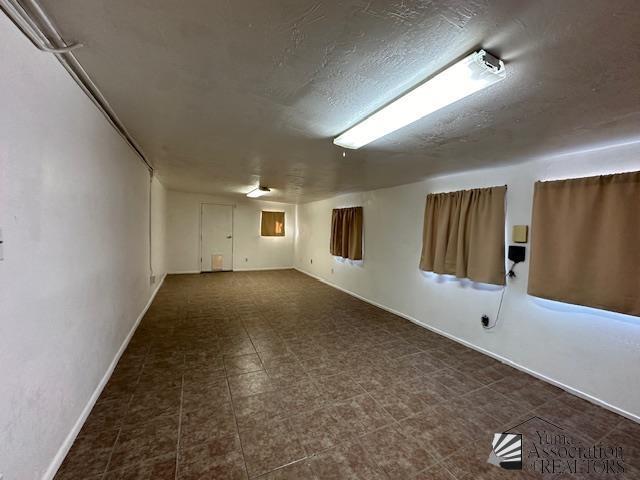empty room with baseboards and a textured ceiling