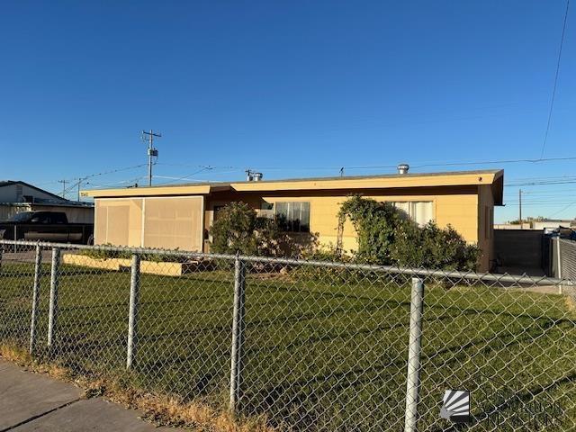 view of front of home featuring fence and a front yard