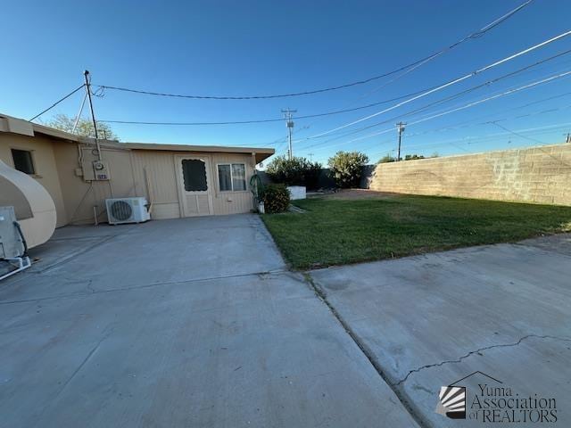 exterior space featuring a lawn, a patio, fence, and ac unit