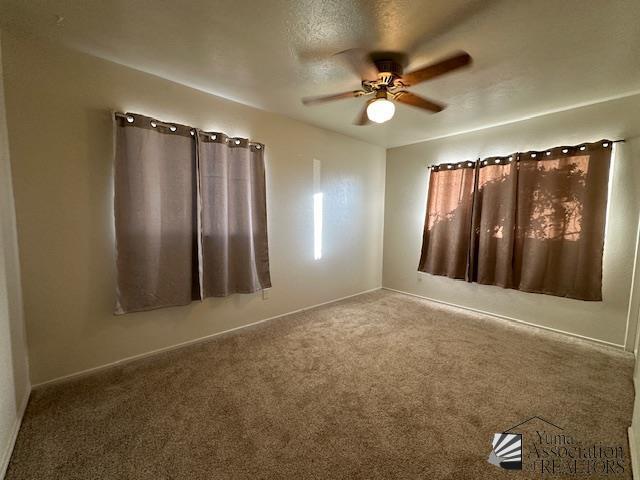 empty room with baseboards, carpet flooring, and ceiling fan