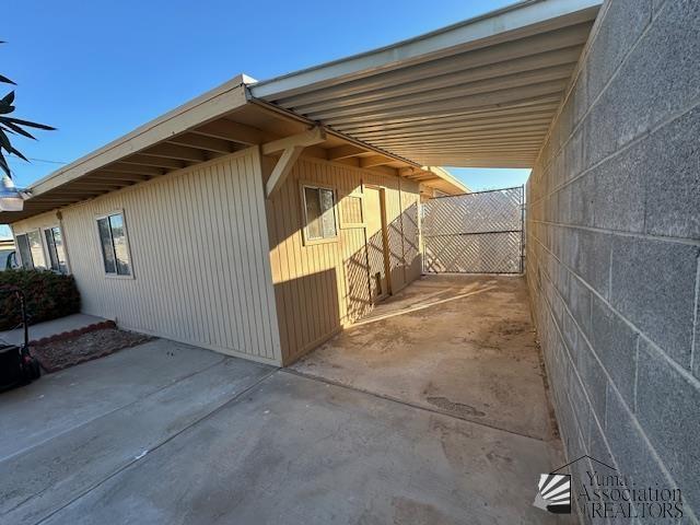 view of property exterior with fence and an attached carport