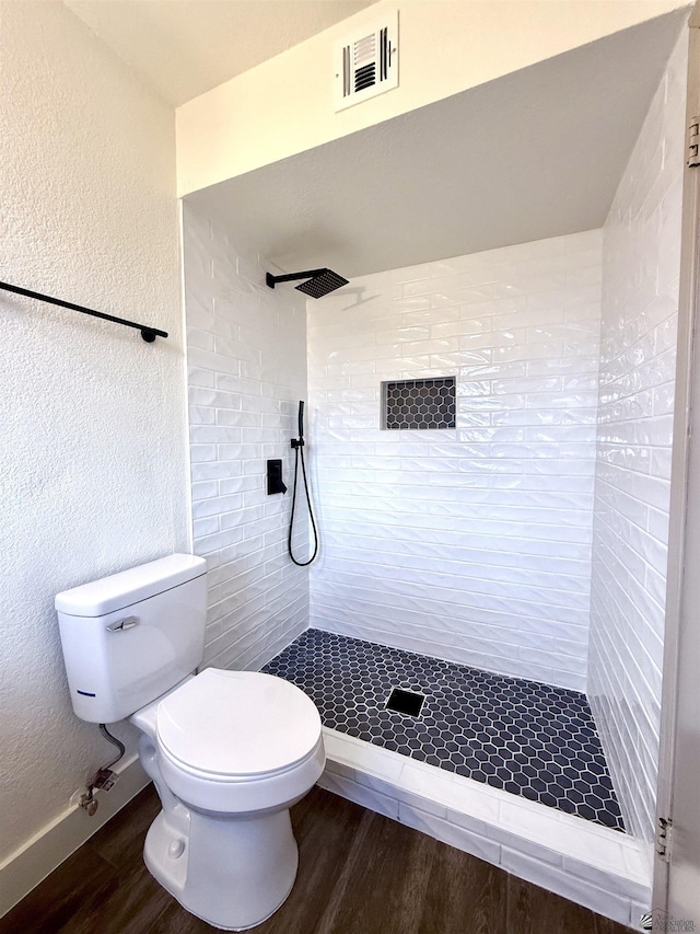 2472 S 18th Ave, Yuma, AZ 85364 - bathroom featuring wood finished floors, toilet, tiled shower, and a textured wall