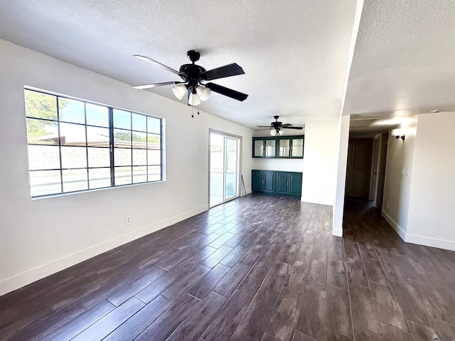 2472 S 18th Ave, Yuma, AZ 85364 - unfurnished living room featuring a textured ceiling, ceiling fan, dark wood finished floors, and baseboards