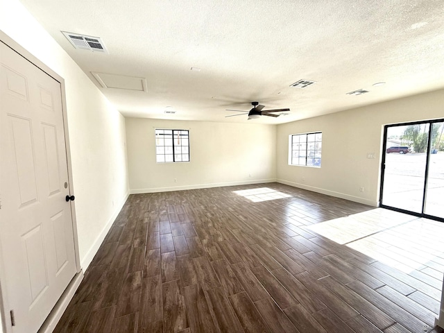 2472 S 18th Ave, Yuma, AZ 85364 - empty room featuring dark wood-type flooring, healthy amount of natural light, baseboards, and a textured ceiling