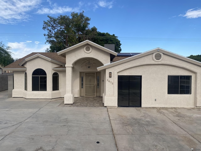 2472 S 18th Ave, Yuma, AZ 85364 - view of front of home featuring stucco siding, roof mounted solar panels, and a shingled roof