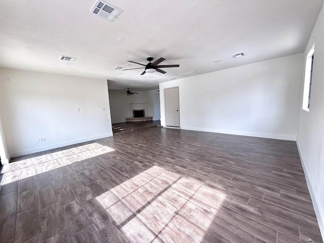 2472 S 18th Ave, Yuma, AZ 85364 - unfurnished living room with wood finish floors, baseboards, a ceiling fan, and a brick fireplace