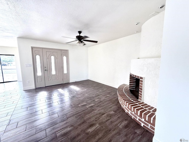 2472 S 18th Ave, Yuma, AZ 85364 - foyer with a brick fireplace, a ceiling fan, dark wood-style flooring, baseboards, and a textured ceiling