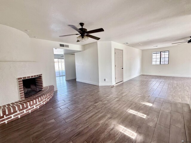 2472 S 18th Ave, Yuma, AZ 85364 - unfurnished living room with ceiling fan, wood tiled floors, a fireplace, baseboards, and a textured ceiling