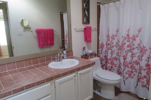 bathroom featuring vanity, toilet, and curtained shower