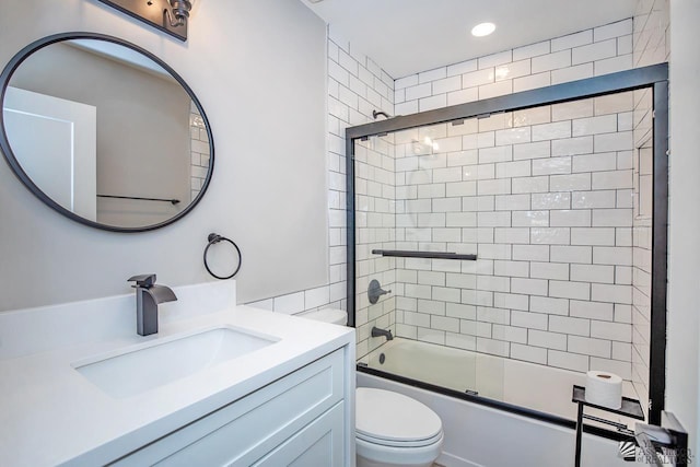 full bathroom featuring vanity, shower / bath combination with glass door, and toilet