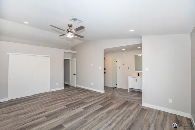 interior space featuring hardwood / wood-style flooring, ceiling fan, sink, and vaulted ceiling