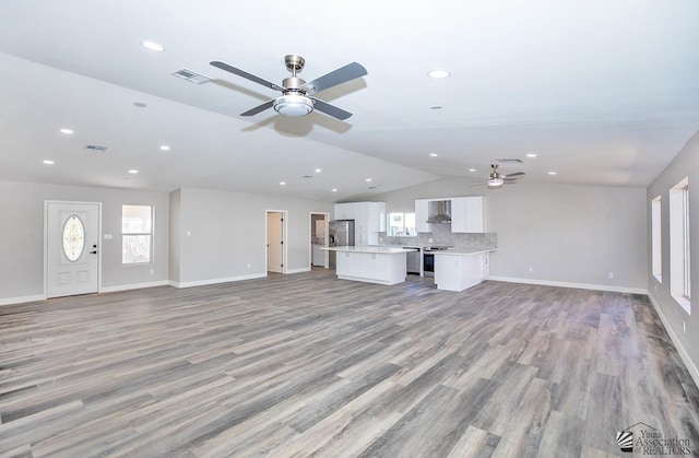 unfurnished living room featuring lofted ceiling, ceiling fan, and light hardwood / wood-style flooring