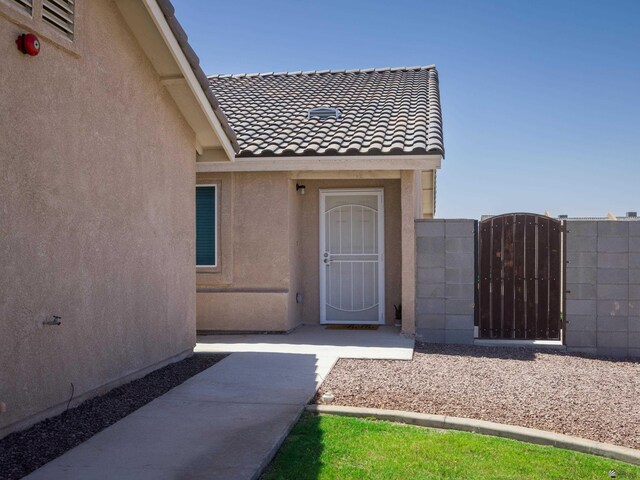 7335 E 36th Rd, Yuma, AZ 85365 - doorway to property with stucco siding, a gate, and a tiled roof