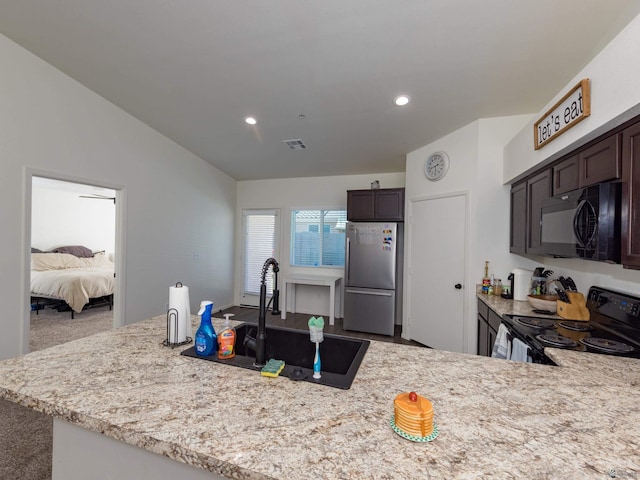 7335 E 36th Rd, Yuma, AZ 85365 - kitchen with black appliances, dark brown cabinetry, recessed lighting, carpet floors, and a peninsula