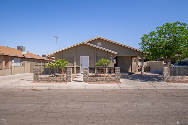 view of front of property featuring concrete driveway, fence, and stucco siding
