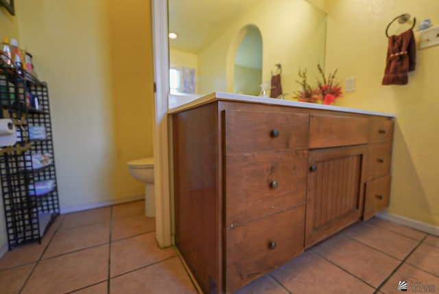 bathroom featuring tile patterned flooring, baseboards, toilet, and vanity