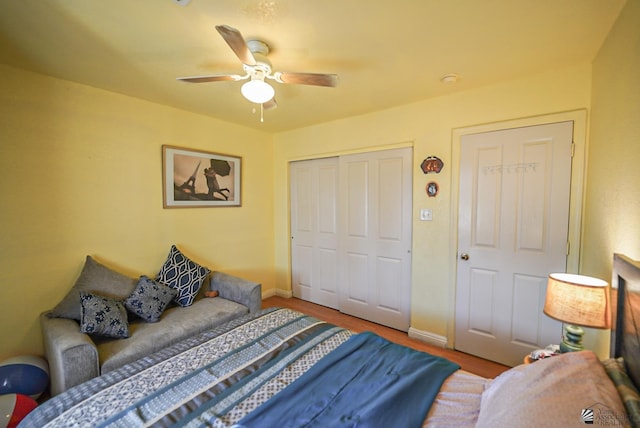 bedroom featuring a closet, a ceiling fan, baseboards, and wood finished floors