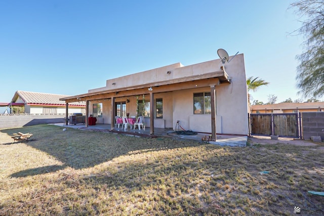 back of property featuring a fenced backyard, a patio, stucco siding, and a lawn