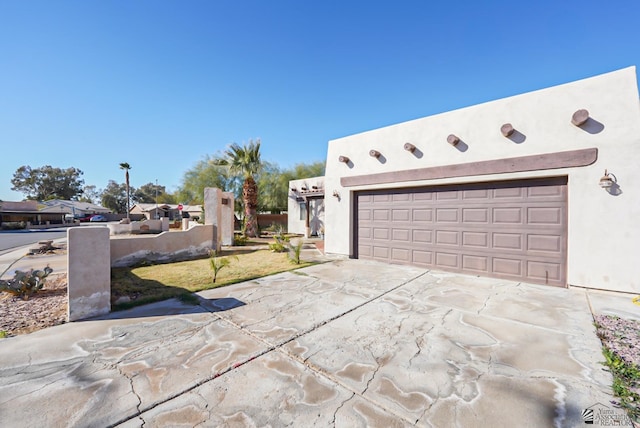 view of side of property featuring an attached garage, stucco siding, and driveway