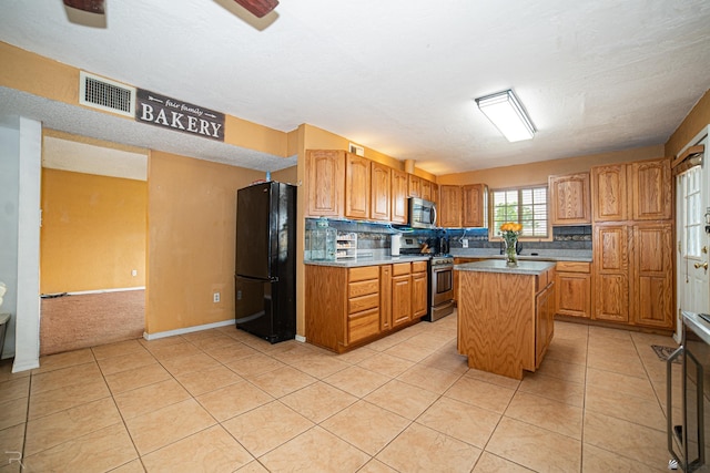 2556 W 14th St, Yuma, AZ 85364 - kitchen with stainless steel appliances, a kitchen island, backsplash, light tile patterned floors, and baseboards