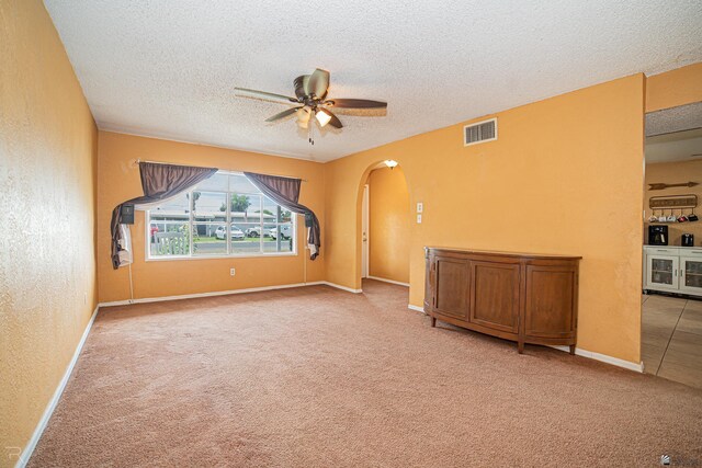 2556 W 14th St, Yuma, AZ 85364 - spare room with arched walkways, light colored carpet, a textured ceiling, a ceiling fan, and baseboards