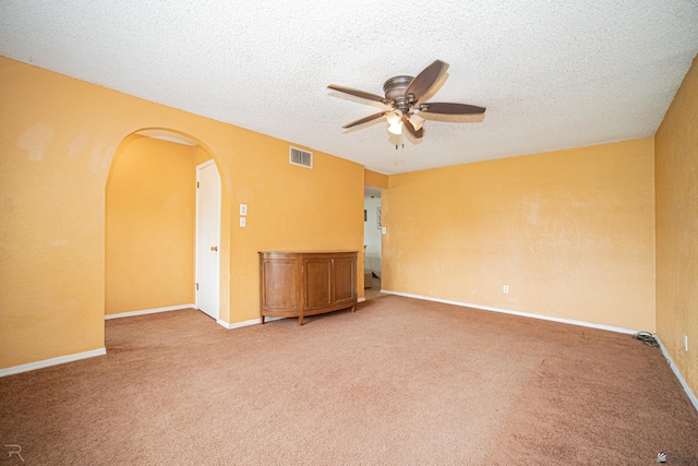 2556 W 14th St, Yuma, AZ 85364 - empty room with a ceiling fan, arched walkways, light carpet, a textured ceiling, and baseboards