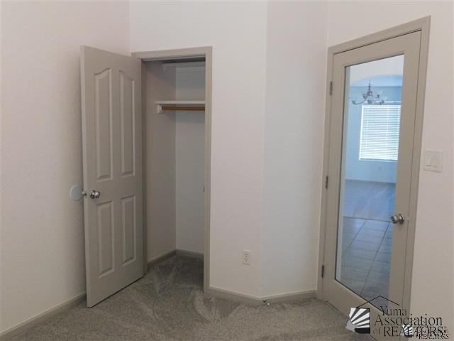 11785 E 27th Pl, Yuma, AZ 85367 - unfurnished bedroom featuring carpet flooring and baseboards