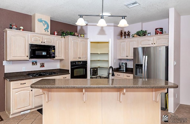 13400 S Onammi Ave, Yuma, AZ 85367 - kitchen featuring black appliances, light tile patterned floors, dark countertops, a kitchen bar, and a textured ceiling
