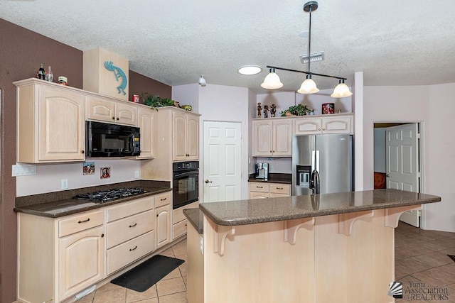 13400 S Onammi Ave, Yuma, AZ 85367 - kitchen featuring black appliances, light tile patterned floors, dark countertops, a breakfast bar, and a textured ceiling