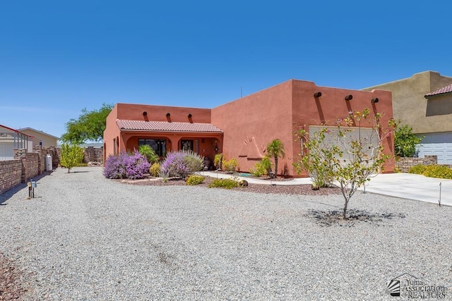 13400 S Onammi Ave, Yuma, AZ 85367 - pueblo-style house with concrete driveway, a tile roof, an attached garage, and stucco siding