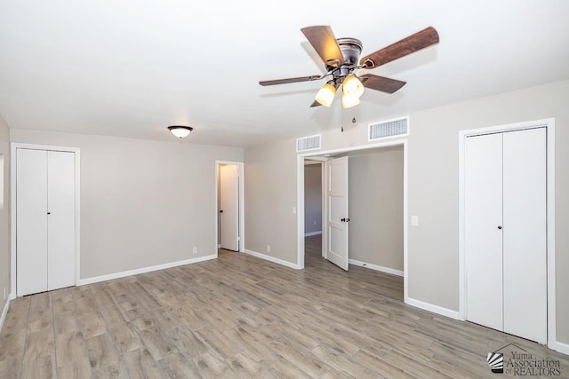 2735 S Mesa Ave, Yuma, AZ 85364 - unfurnished bedroom with light wood-type flooring, baseboards, two closets, and a ceiling fan