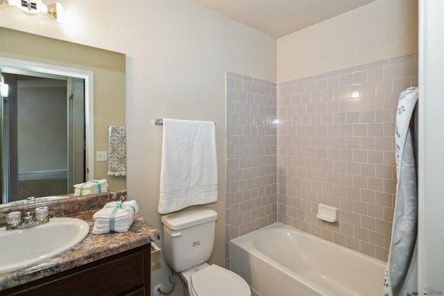 bathroom with toilet,  shower combination, and vanity