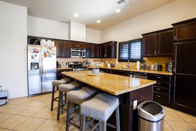7942 E 36th Ln, Yuma, AZ 85365 - kitchen with stainless steel appliances, a sink, a center island, light tile patterned floors, and tasteful backsplash